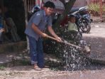 wpid-warga-siram-jalan-untuk-hindari-debu